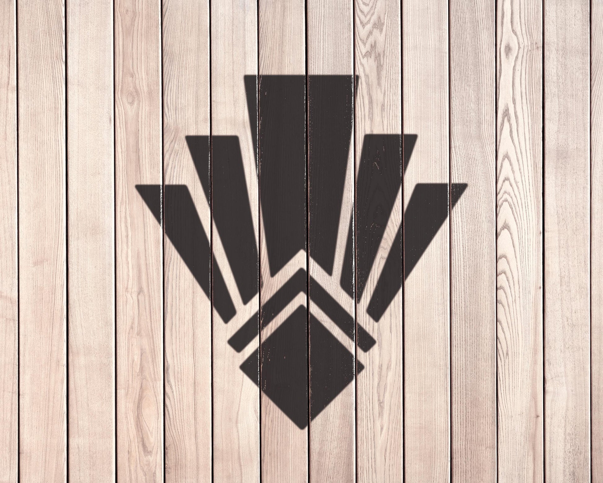 a wooden wall with a stylized black geometric design in the center.