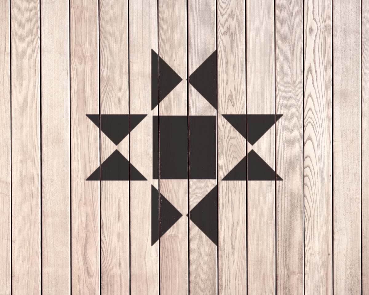 a wooden surface with a black geometric pattern composed of triangles and a square.