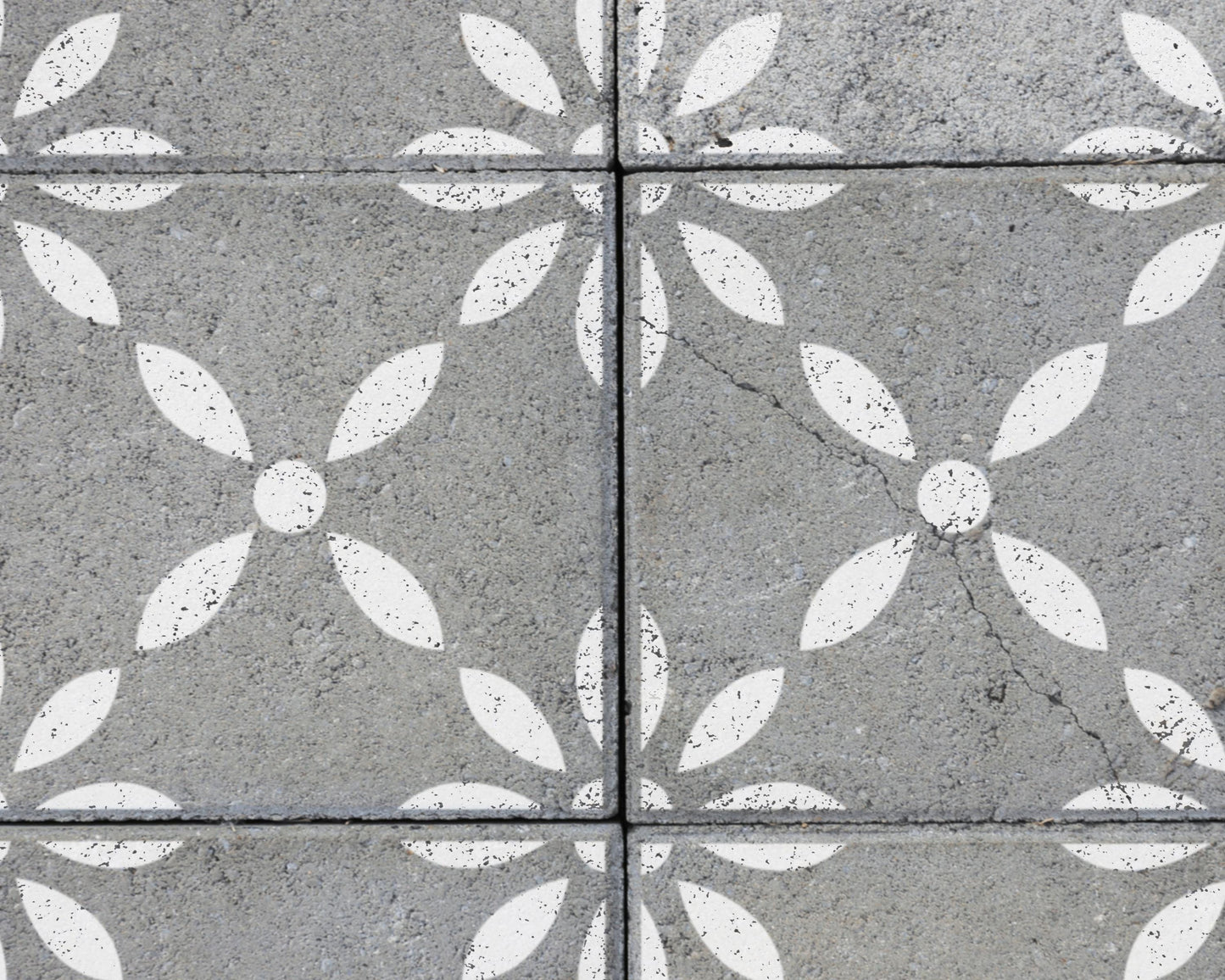 a close-up view of a concrete surface with a repeating pattern of white flower-like shapes.