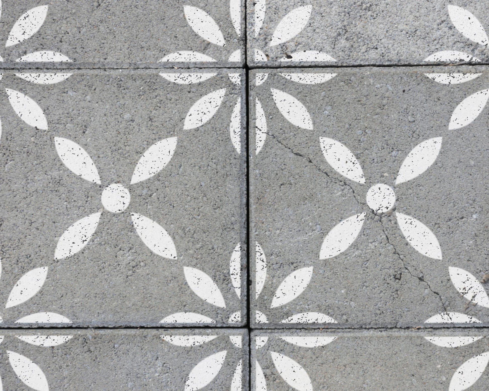 a close-up view of a concrete surface with a repeating pattern of white flower-like shapes.