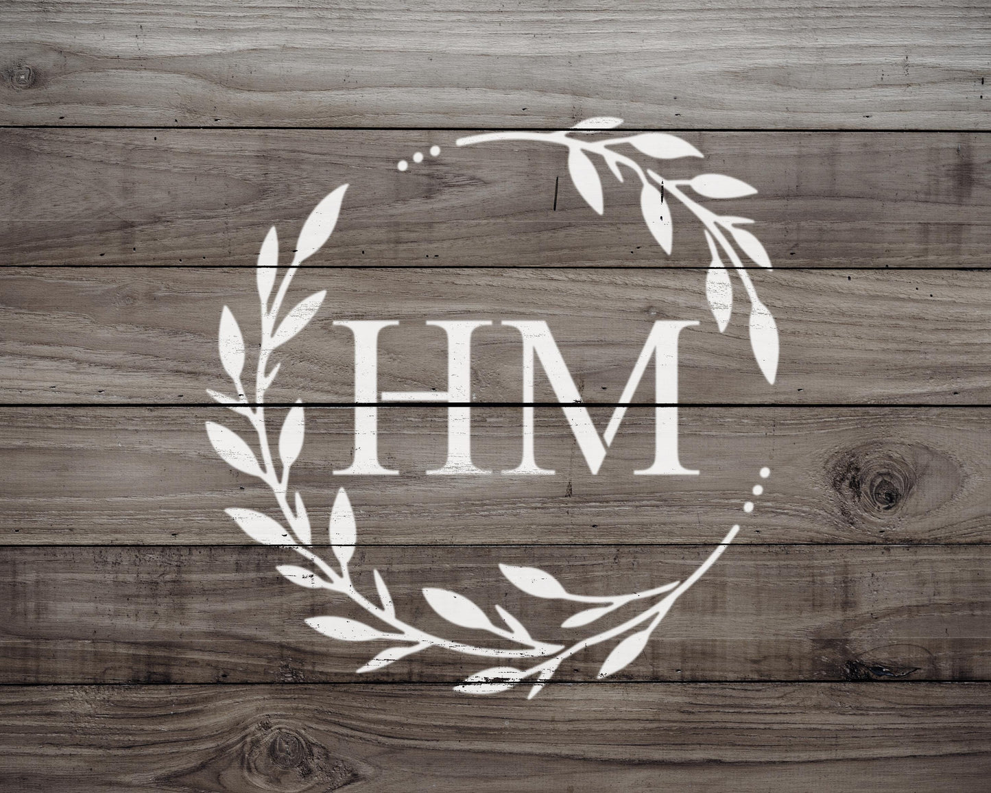 a monogrammed logo with the letters "HIM" displayed in a wreath-like design on a wooden background.