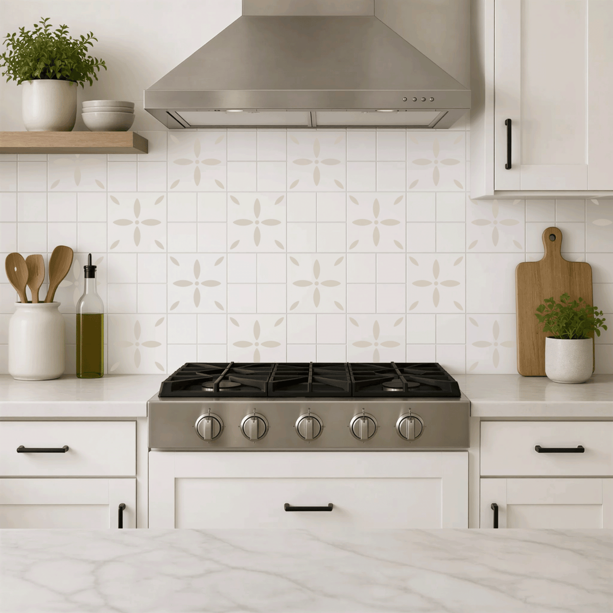 A modern kitchen with a gas range, white cabinets, and a tile backsplash featuring a repeating pattern of white flowers. The kitchen also includes a potted plant, wooden cutting board, and various kitchen utensils.