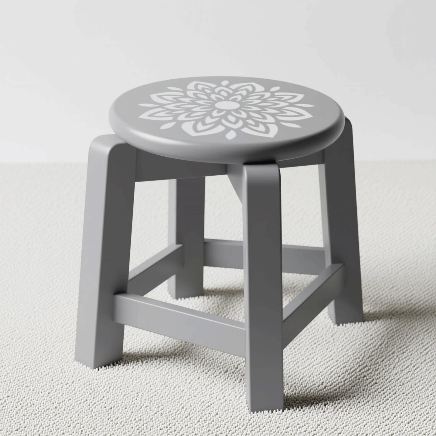 A gray stool with a white floral design on the seat.