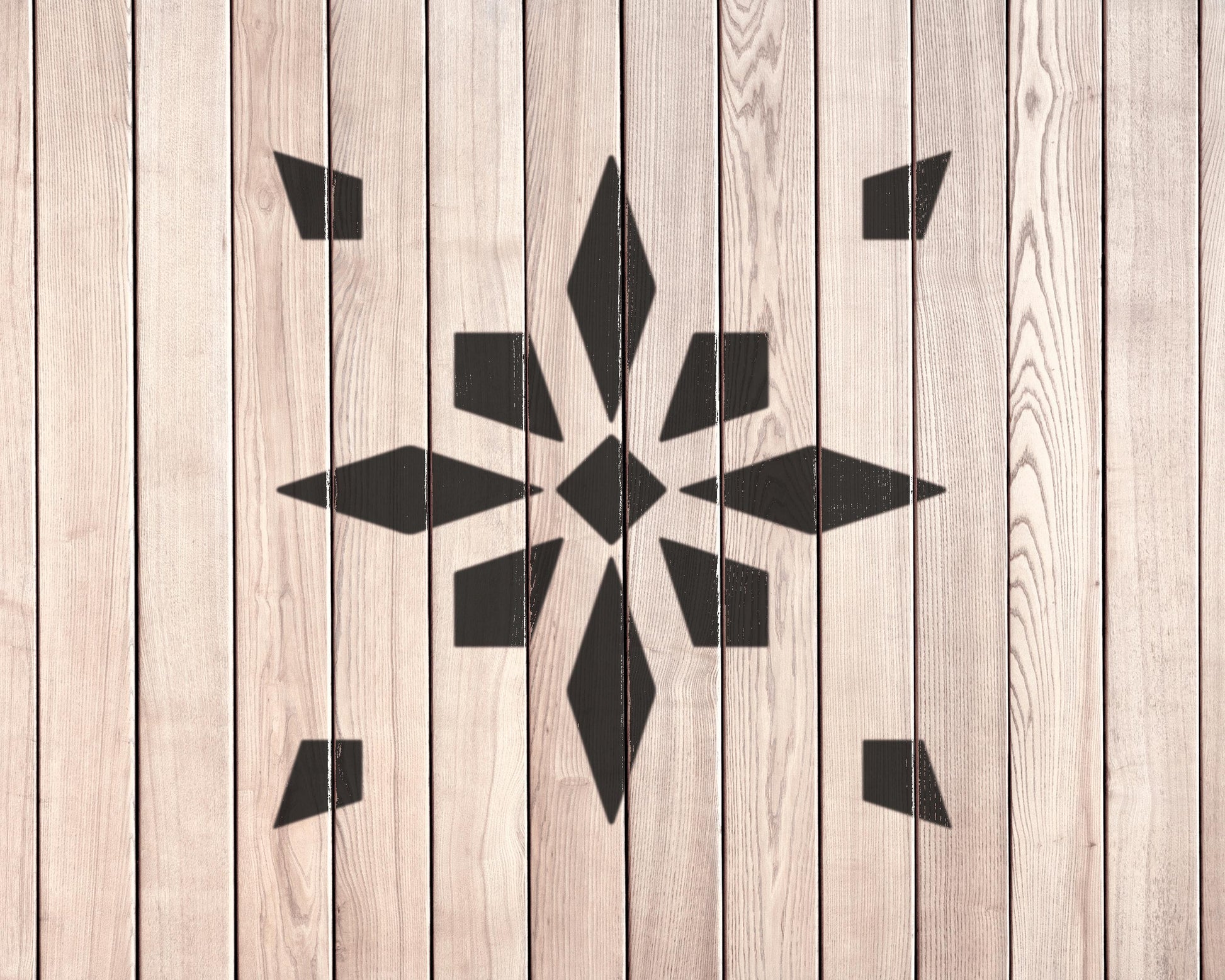 a wooden wall with a black geometric pattern in the center.