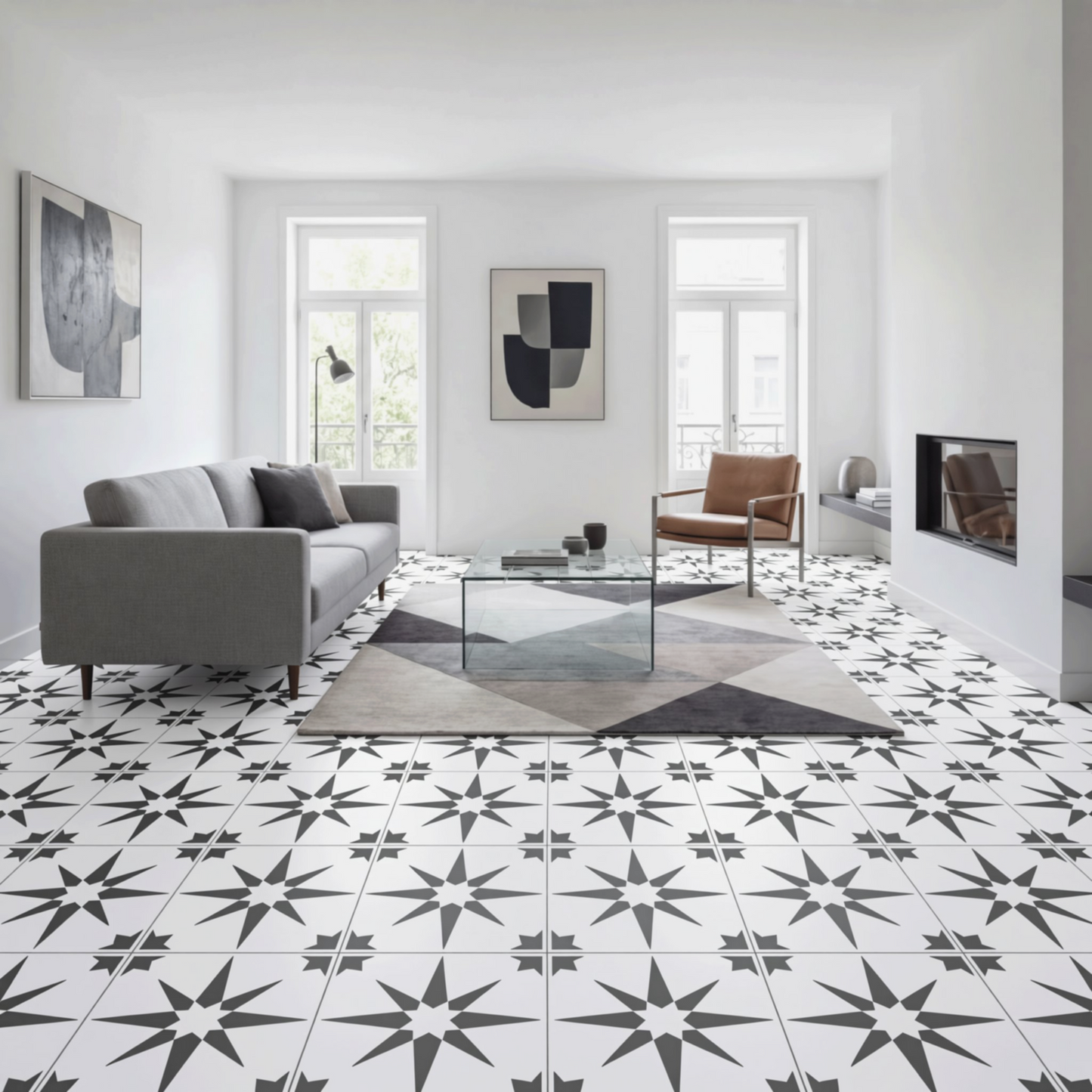 a modern living room with a gray sofa, a glass coffee table, and a brown leather armchair. The room has a white and black star-patterned tile floor, and the walls are painted white. There are two windows in the room, one on the left and one on the right, allowing natural light to enter the space. The room also features artwork and a fireplace, creating a cozy and stylish atmosphere.