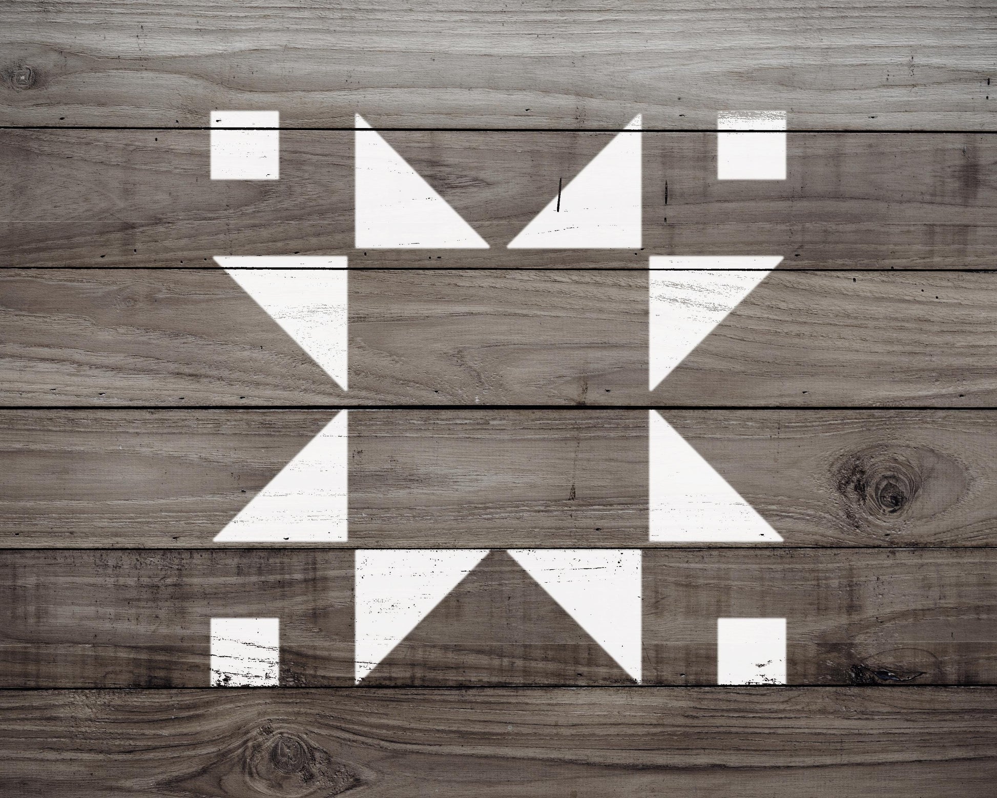 a close-up view of a wooden surface with a geometric pattern of white triangles arranged in a diamond shape.