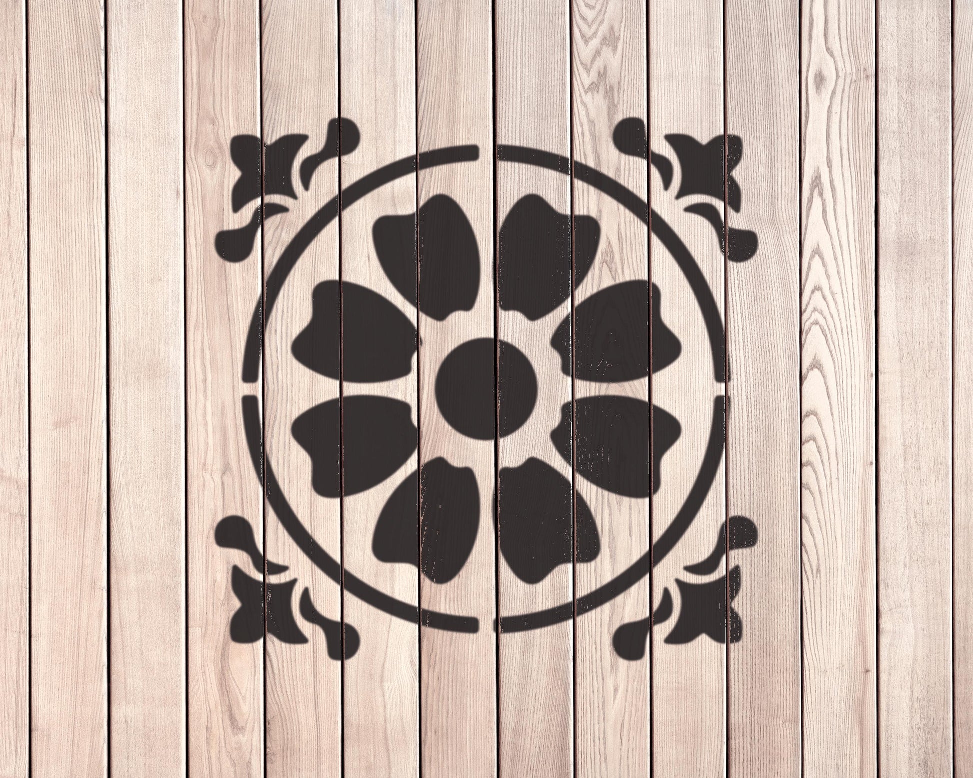a wooden wall with a black floral design in the center.