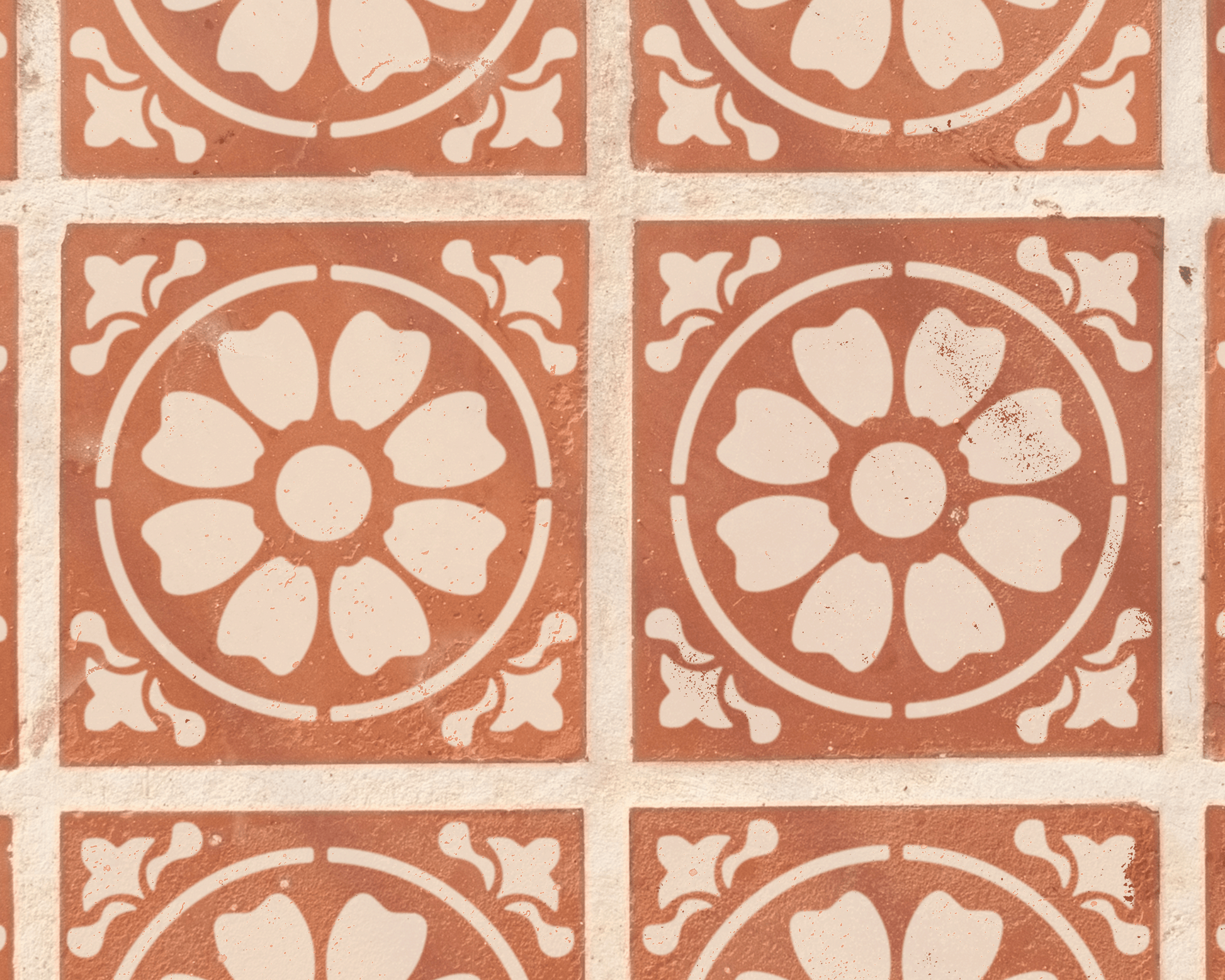 a repeating pattern of circular floral designs on a brick wall.