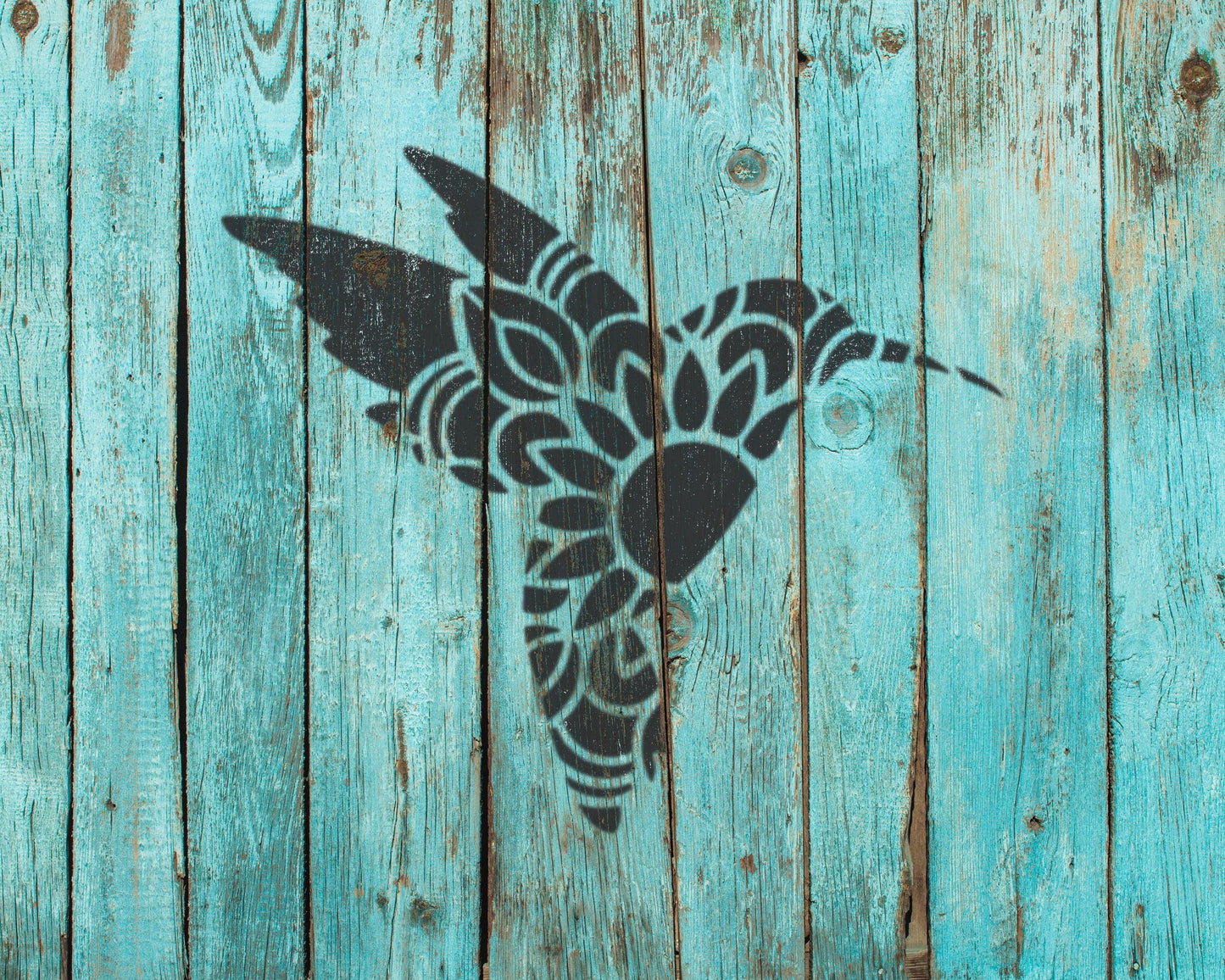 a black silhouette of a bird, possibly a hummingbird, against a blue wooden background.