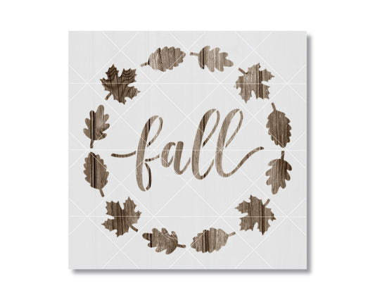 a wreath made of wooden leaves surrounding the word "fall" written in a cursive script.