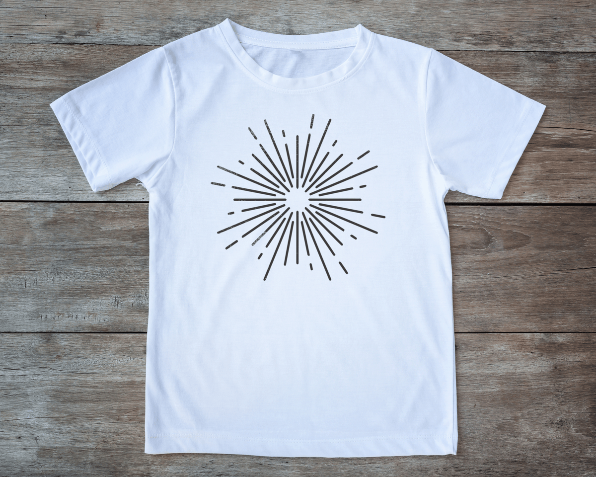 A white t-shirt with a black sunburst design on it, laid out on a wooden surface.